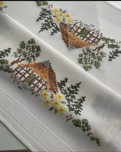 two cross stitch designs on white fabric