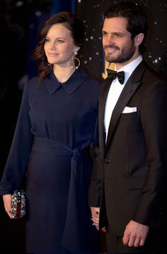 a man and woman standing next to each other on a red carpet with stars in the background