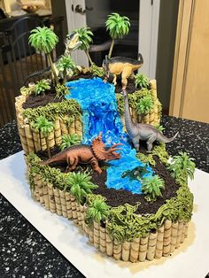 a cake made to look like an island with dinosaurs on it