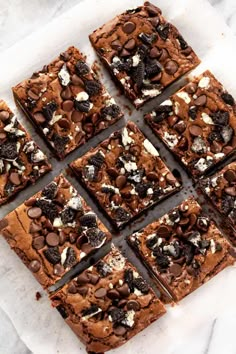 chocolate cookie bars with oreo cookies and white chocolate chips on top, cut into squares