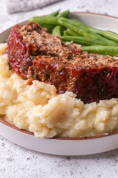 meatloaf and mashed potatoes on a plate with green beans