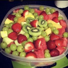 a plastic container filled with fruit on top of a counter