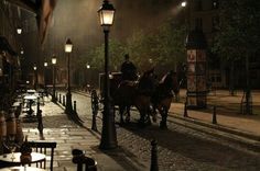 a horse drawn carriage traveling down a street at night