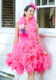 a woman in a pink dress standing next to a window with a bird on it