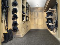 a large walk - in closet with lots of hats and boots on the shelves next to it