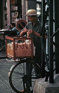 a man standing next to a cart filled with oranges