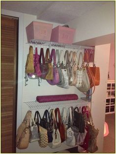 there are many purses and bags hanging on the shelves in this room, all organized together