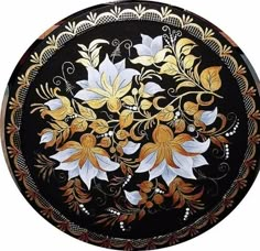 a black and gold plate with flowers on it