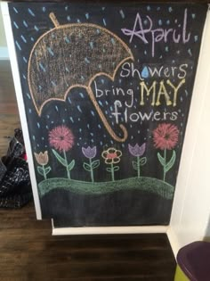 a chalk board with flowers and an umbrella drawn on it in front of a door