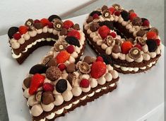 three pieces of chocolate cake with strawberries and other toppings on top of it