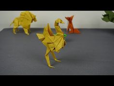 three origami birds standing on top of a gray surface next to each other