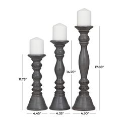 three black candle holders with white candles