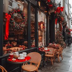 an outdoor cafe with christmas decorations on the windows and tables set up outside for people to eat