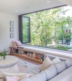 a living room filled with furniture and a large window next to a wall mounted tv