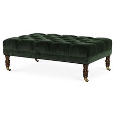 a green velvet bench with wooden legs