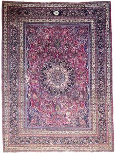 an antique persian rug with floral design on the center, and ornate border around it