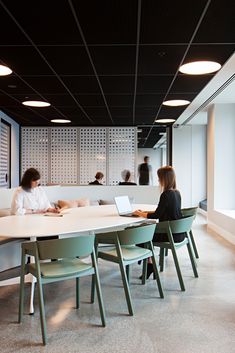 two women sitting at a table in an office