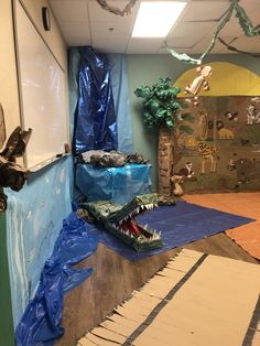 a room that has been decorated with blue tarps and plastic covering the walls, including an alligator's mouth