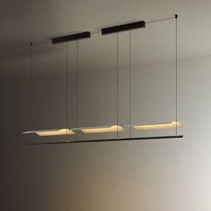 three rectangular lights hanging from the ceiling in an empty room