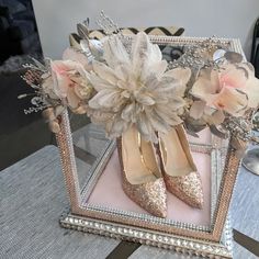 a pair of gold high heels sitting on top of a table next to a mirror