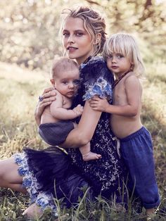 a woman and two children on the cover of a magazine, with trees in the background