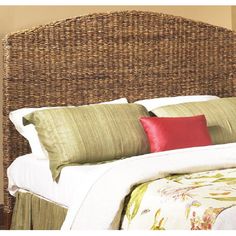 a bed with green and red pillows on top of it's headboard in a bedroom