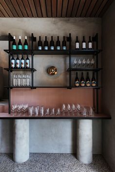 bottles and glasses are lined up on the wall