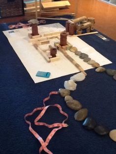 some rocks are laying on the ground near a table with a blue mat and pink ribbon