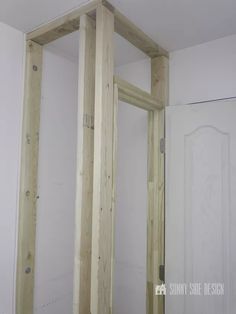 an unfinished room with some wood framing on the wall and door frame in place to be framed