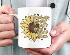 a woman holding a coffee mug with a sunflower on it