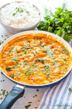 a white bowl filled with food next to rice and cilantro