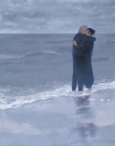 two people standing in the ocean hugging each other