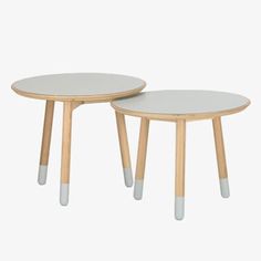 two tables with wooden legs and white tops, one on top of the other side