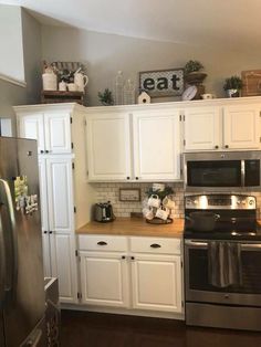 a kitchen with white cabinets and stainless steel appliances