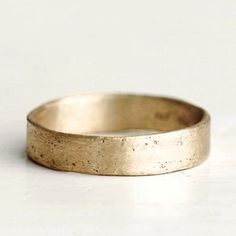 a close up of a gold ring on a white surface with no one around it