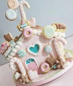 a pink and white gingerbread house decorated with cookies, candy, candies, marshmallows, lollipops and hearts