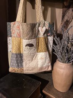 a tote bag sitting on top of a table next to a potted plant