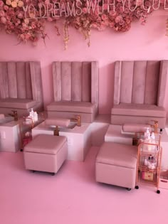 a pink room with chairs and stools in it