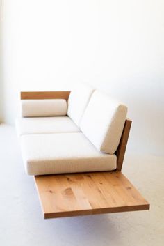 a white couch sitting on top of a wooden table