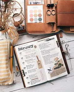 an open book sitting on top of a wooden table next to a purse and other items