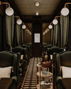 the interior of a train car with green and white chairs, tables, and lamps