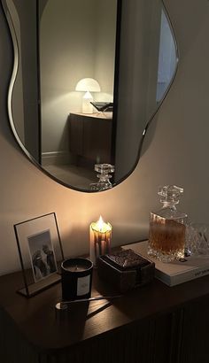 a table with a candle on it and a mirror above it that is reflecting the room