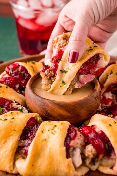 a person is picking up some food from a wooden platter with cranberry sauce on it