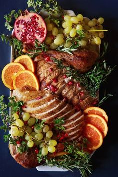 a platter filled with meat, fruit and vegetables