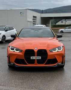 an orange sports car parked in a parking lot