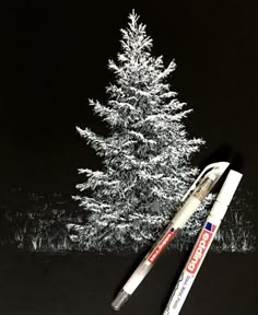 two pens are sitting next to a white christmas tree