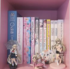 some anime figurines are sitting on a shelf next to books and an umbrella