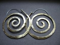 "These swirl hoops are hand pound, shaped and polished. Great for every day. The texture and hand forged quality catches the light and give these simple earrings dimension. Available in solid copper, bronze or sterling silver with hand made ear wires of sterling silver. Large 2 1/8\" H x 1 7/8\" W Ancient spiral meaning: Evolution, Life, Consciousness, Creation Finish: Satin finish is a matte brushed finish. High shine is a brilliant high polish. Each pair is individually shaped, pound and match Spiral Meaning, Sacred Spiral, Spiral Jewelry, Lily Jewelry, Spiral Earrings, Cuff Rings, Everyday Necklace, Everyday Earrings, Simple Earrings