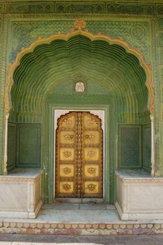 an ornate green and gold building with two large doors