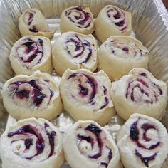 a pan filled with rolls covered in blueberry filling